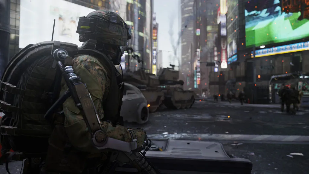 A soldier in an exo suit stands in the middle of a street in a busy city, watching zombies run off in another direction in Call of Duty: Advanced Warfare.