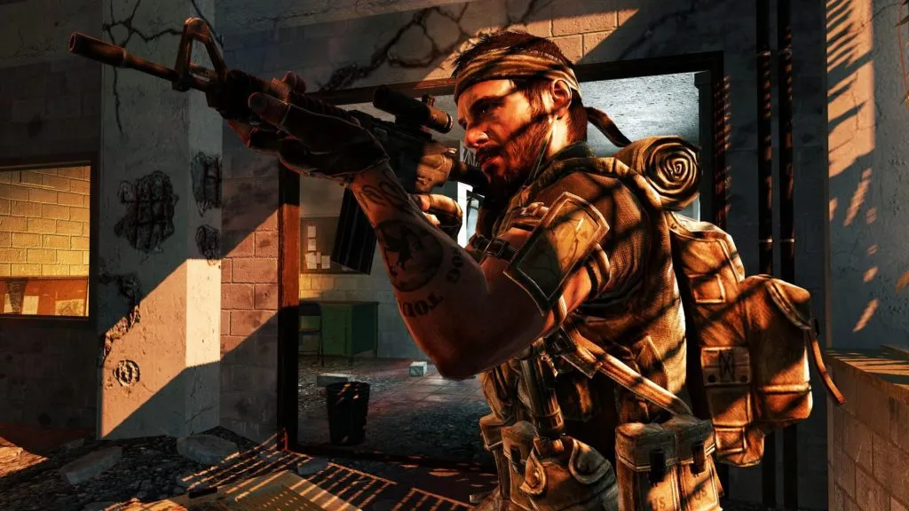 Frank Woods from Call of Duty: Black Ops, a soldier , aiming at an enemy off-screen while standing in an abandoned hallway.