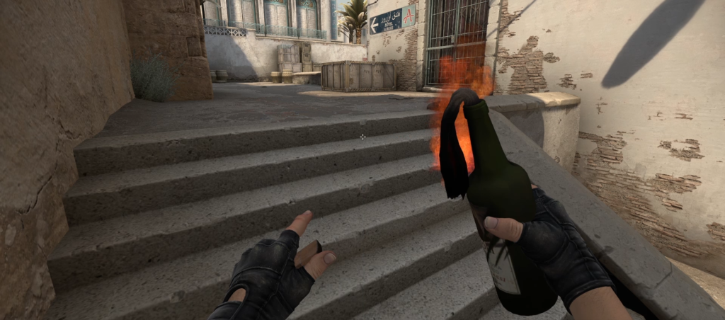 A T player holding a Molotov cocktail on A short, preparing to throw it onto A site on Dust 2 in CS:GO.